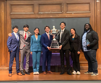 image of Plano West Speech and Debate qualifiers and teacher with trophy.